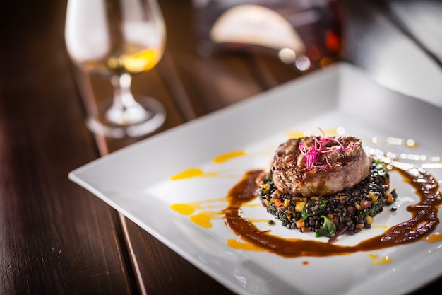 Filete de ternera a la parrilla con lentejas negras mezcladas con ron de coñac vegetal o brandy como bebida