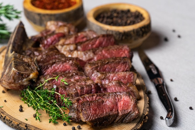 Filete de ternera a la parrilla medio raro en rodajas sobre tabla de cortar de madera con especias