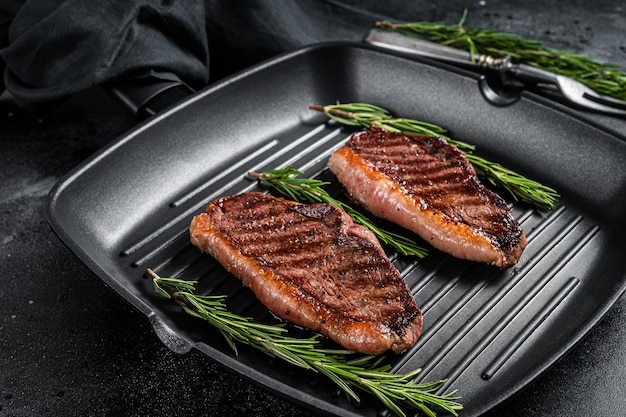 Filete de ternera a la parrilla o carne asada Picanha brasileña en una sartén a la parrilla Fondo negro Vista superior