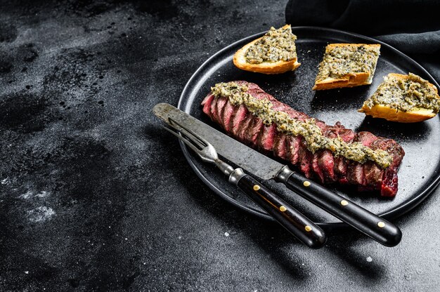 Filete de ternera a la parrilla o machete de mármol. Fondo negro. Vista superior.