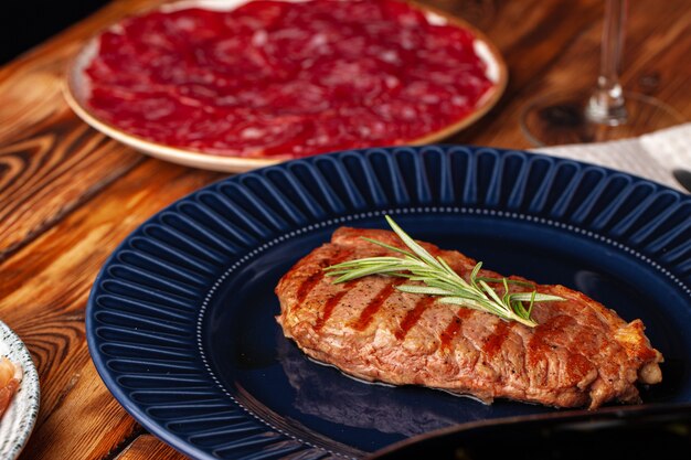 Filete de ternera a la parrilla servido en placa azul en la mesa