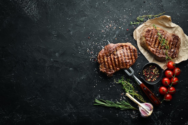 Filete de ternera a la parrilla en el tenedor En la mesa envejecida Vista superior Espacio libre para el texto