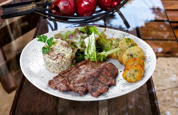 Filete de ternera con patatas y arroz en fondo blanco aislado