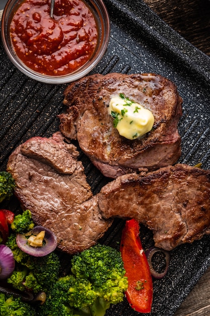 Filete de ternera a la plancha con mantequilla de ajo y verduras. Carne con pimiento asado, brócoli y cebolla.