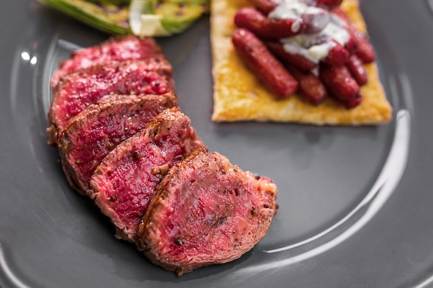 Filete de ternera en rodajas con verduras asadas en un plato