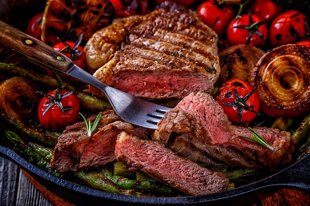 Filete con verduras a la plancha en una sartén