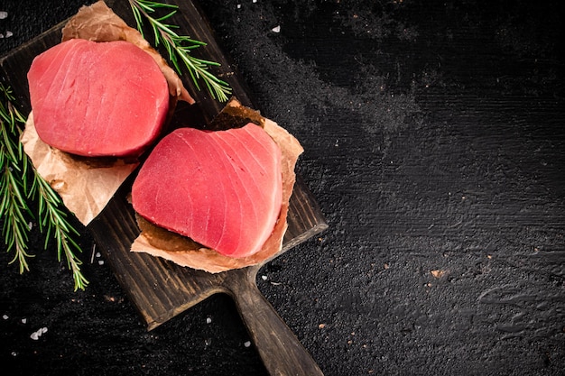 Filetes de atún crudo en una tabla de cortar de romero
