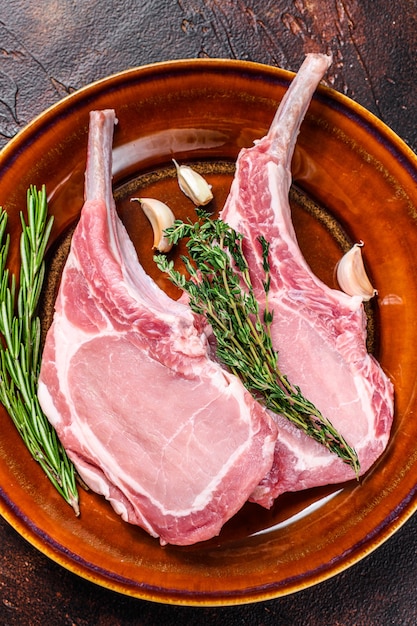 Foto filetes de carne de chuletas de cerdo cruda con pimienta y sal