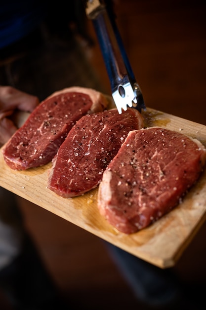 Filetes de carne cruda fresca Prime Black Angus sobre tabla de madera, cruda Tabla de cortar deliciosa carne de res.