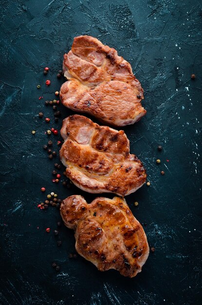 Filetes de carne con romero Barbacoa a la parrilla Sobre un fondo de piedra negra Vista superior Espacio de copia libre