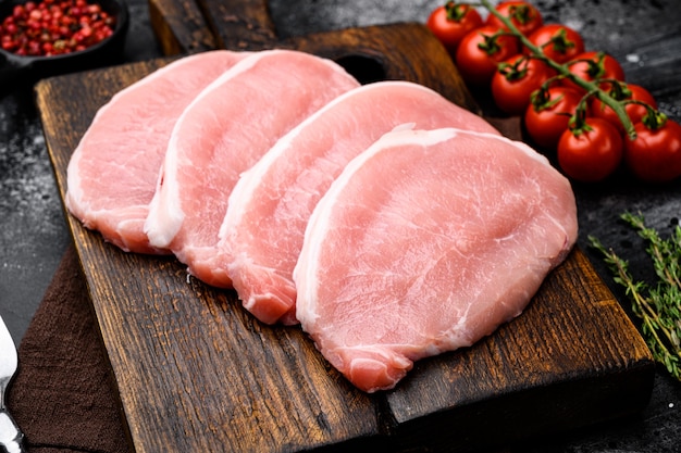 Filetes de cerdo Conjunto de carne cruda, sobre fondo de tabla de piedra oscura negra