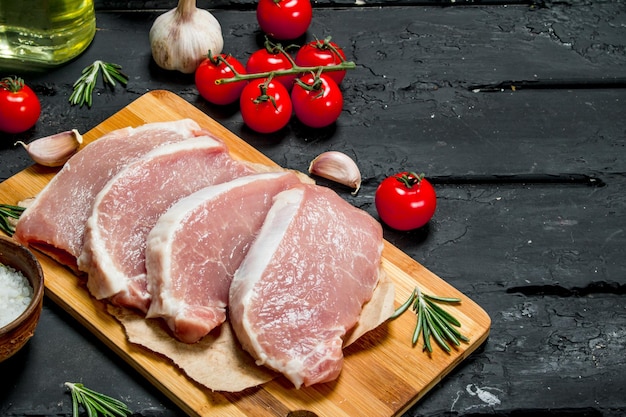 Filetes de cerdo crudo con tomates y especias