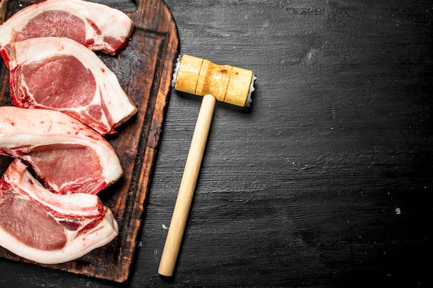 Filetes de cerdo crudos sobre una tabla para cortar. en la pizarra negra.