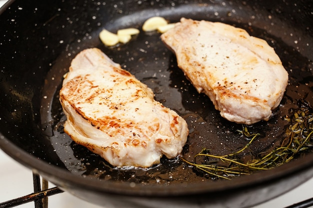 Filetes de cerdo jugosos en la sartén, wiev superior de cocinar alimentos