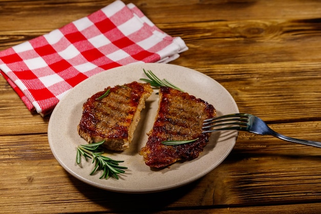 Filetes de cerdo a la parrilla con romero sobre mesa de madera