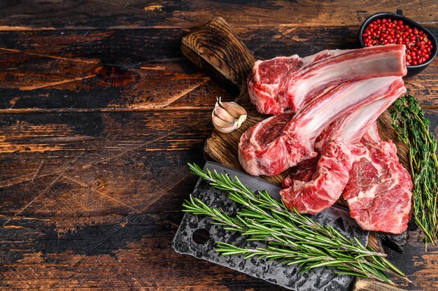 Filetes de chuletas crudas de cordero en tabla de cortar de carnicero