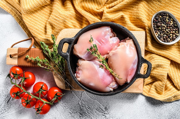 Filetes de coxas de frango cru desossadas. Fundo branco.