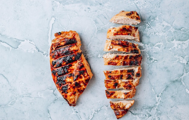 Filetes de frango grelhado em alimentos de proteína de vista superior de fundo de mármore cinza