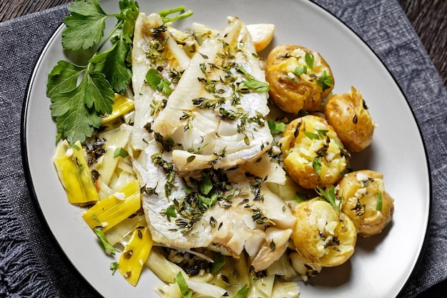 Filetes de peixe branco no travesseiro de alho-poró refogado e batatas baby ao lado