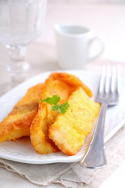 Filetes de peixe frito em farinha de milho em um prato branco