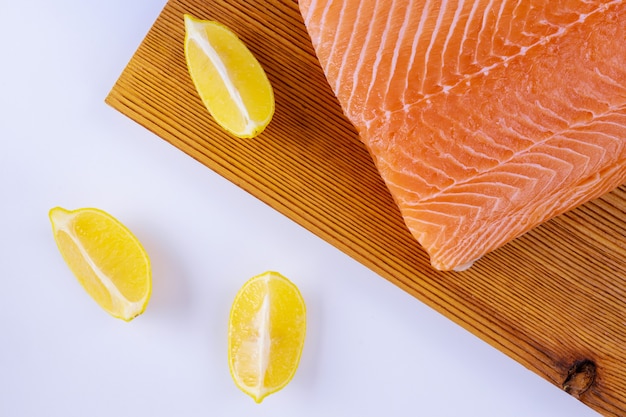 Filetes de salmão crus em tábua de madeira em branco