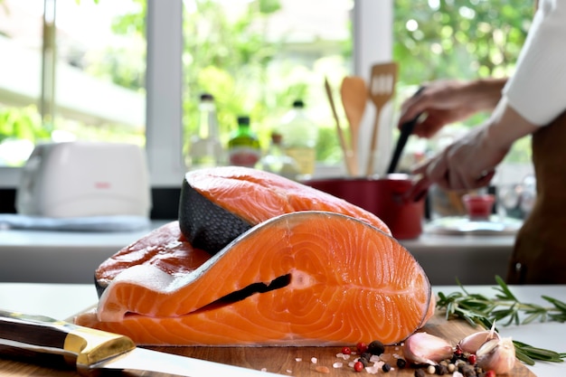 Filetes de filete de salmón crudo fresco con ingrediente en una tabla para cortar en la cocina