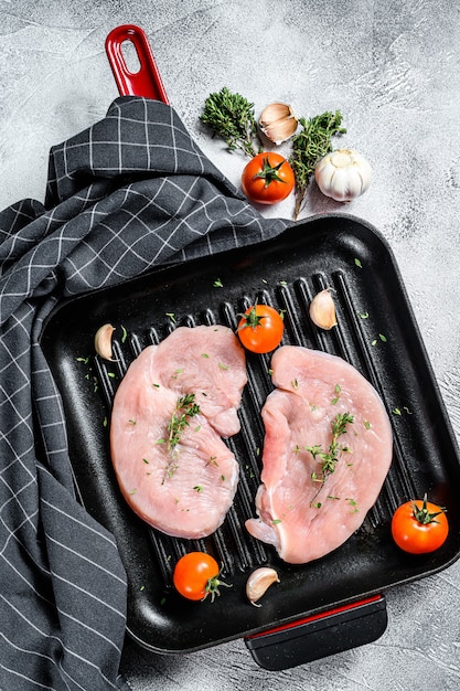 Filetes de pavo crudo en una sartén negra