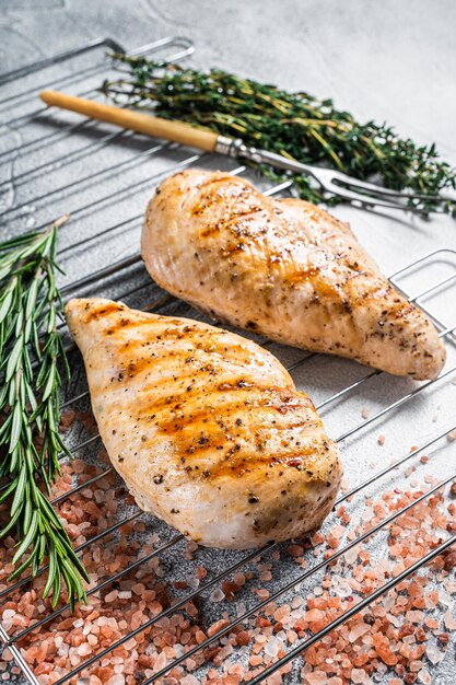 Filetes de pechuga de pollo a la parrilla cocinados en una barbacoa de verano. Fondo gris. Vista superior.