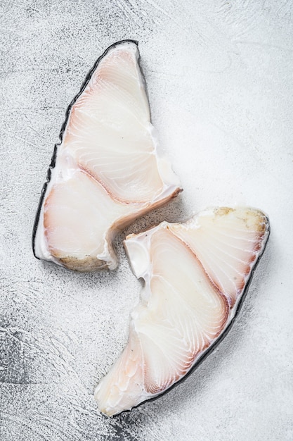 Filetes de pescado crudo de tiburón en una mesa de cocina en blanco. Vista superior.