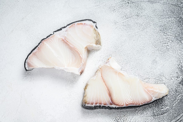 Filetes de pescado crudo de tiburón en una mesa de cocina. Fondo blanco. Vista superior.