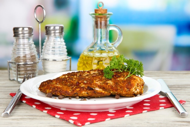 Filetes de pollo asado en plato blanco sobre fondo brillante