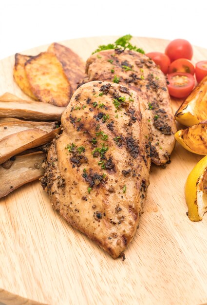 Filetes de pollo a la plancha con verduras en tablero de madera