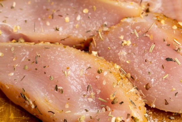 Filetes de pollo recién lavados y desollados con sal y especias listos para cocinar