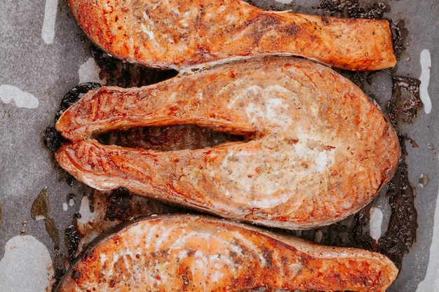 Filetes de salmón cocidos en un primer plano de una bandeja para hornear. Filetes de pescado frito rojo. Trozos de salmón al horno