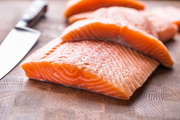 Filetes de salmón crudo de primer plano en la mesa de madera.