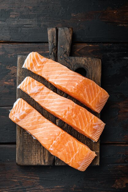 Filetes de salmón crudo sobre mesa de madera antigua