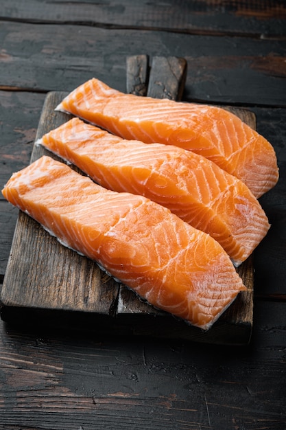 Filetes de salmón crudo, sobre mesa de madera antigua