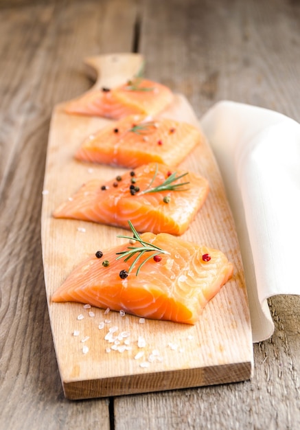 Filetes de salmón crudo sobre la plancha de madera