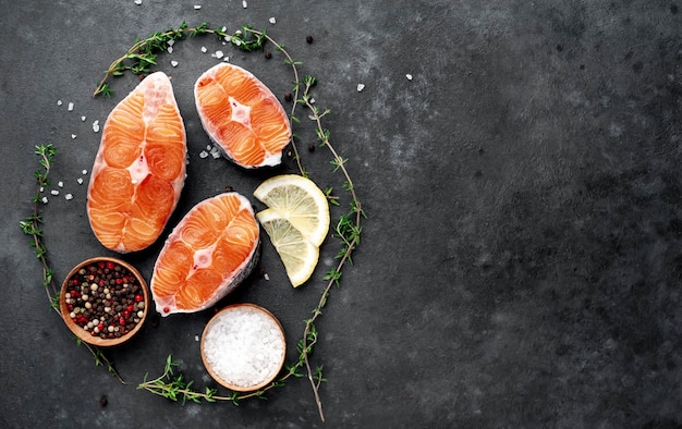 Filetes de salmón crudos frescos con sal, pimienta, limón