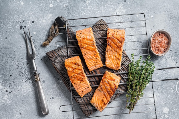 Filetes de salmón a la parrilla con sal, pimienta y hierbas a la parrilla Fondo gris Vista superior