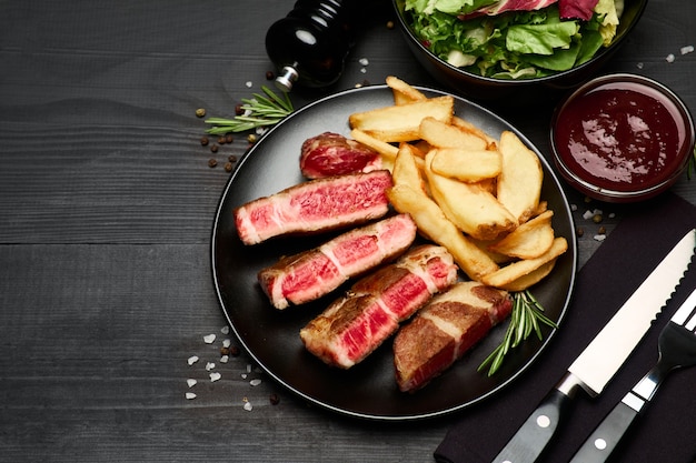 Filetes de ternera asada a la parrilla sobre placa de cerámica negra