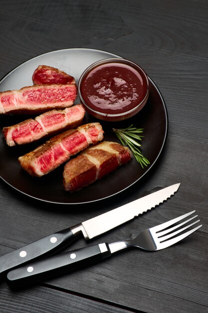 Filetes de ternera asada a la parrilla sobre placa de cerámica negra