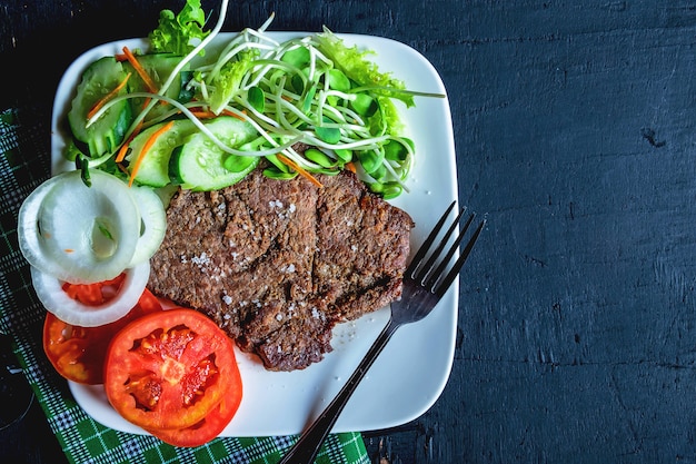 Filetes de ternera a la parrilla y ensaladas saludables en la mesa