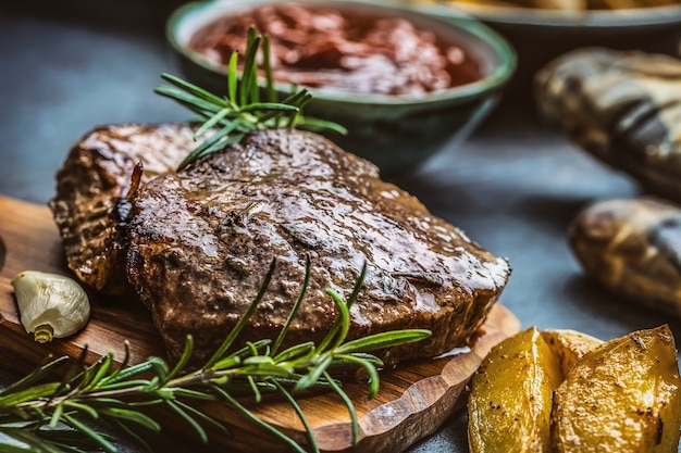 Filetes de ternera a la plancha con salsa barbacoa patatas asadas y romero.