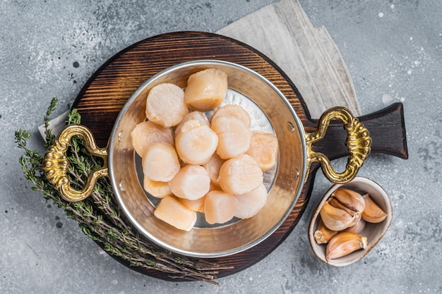 Filetes de vieiras crudas en una sartén Fondo gris Vista superior