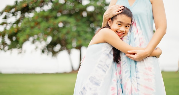 Filha abraçando a mãe no parque