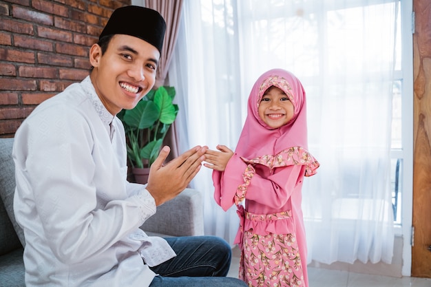 Filha agitar as mãos para seu pai no eid mubarak