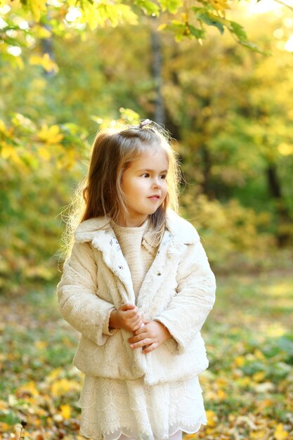 Filha bonitinha em pé no outono park a