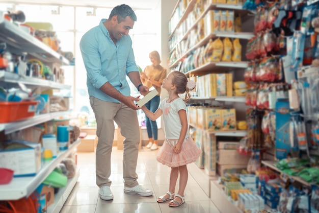 Filha chegando ao papai com comida para seu cachorro enquanto fazia compras