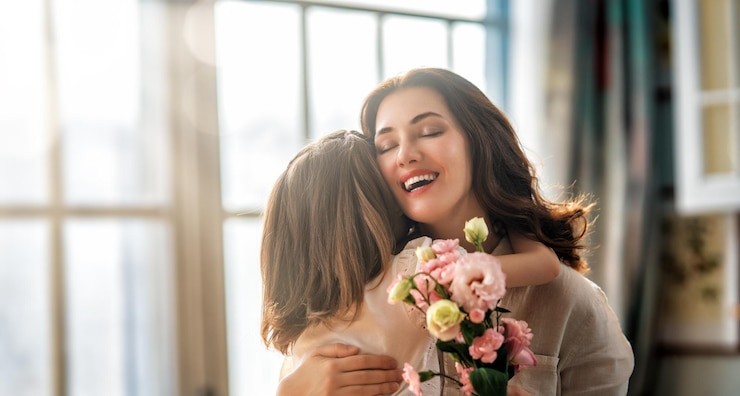 Foto filha dando buquê de flores para a mãe